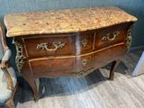 a marble top chest of drawers next to a chair