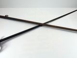pair of two old swords on a white surface with a pair of scissors
