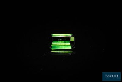 une image représentant une lumière verte qui brille sur une surface noire