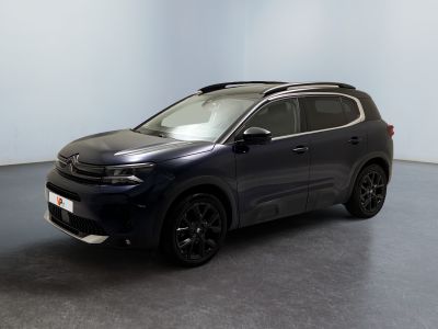 a black suv parked in a room with a white wall