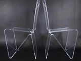 une paire de chaises en acrylique transparent sur fond noir