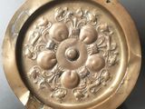 an image of a gold plate with a flower design on it