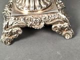 a silver plate with a glass bowl on top of it