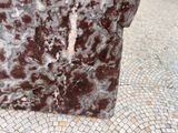 a brown and white marble bench on a tiled floor