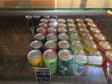many cans of soda on display in a glass case