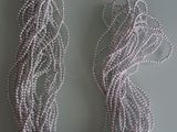 collier composé de perles argentées sur fond gris