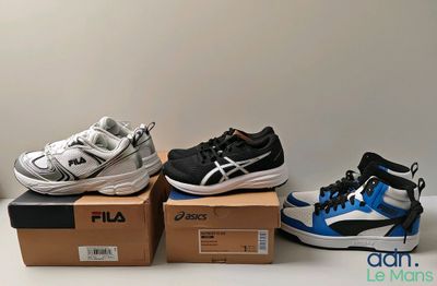 three pairs of shoes are sitting on top of boxes on a table