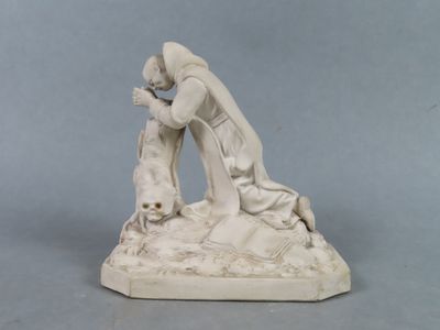 une statue représentant une femme agenouillée sur un rocher avec un chien