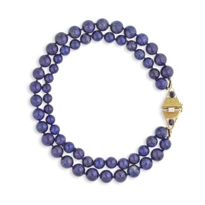 un gros plan d'un bracelet en perles bleues sur fond blanc