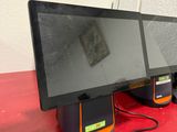 three monitors sitting on a red table next to each other