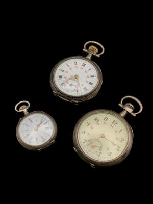 trois montres de poche anciennes sur fond noir, avec un fond noir