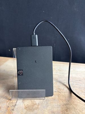 a small black device that is connected to a charger on a table