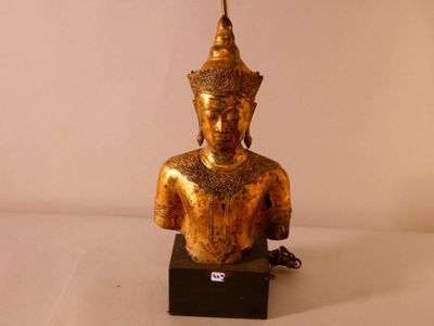 statue représentant une personne à la tête dorée, posée sur un socle noir