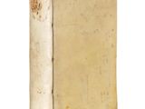 an old book sitting on top of a white table next to a white wall