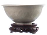 a white bowl sitting on top of a wooden stand