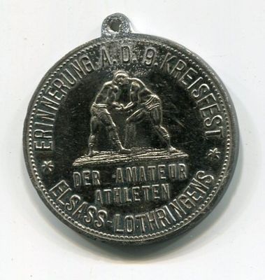an old silver medal with a picture of a man and a woman on it