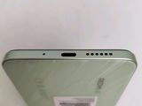 the back of a green phone with a sticker on it ' s side