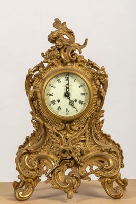 une horloge en or posée sur une table en bois