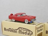 two red toy cars sitting on top of a box
