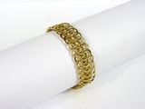 un gros plan d'un bracelet plaqué or posé sur une serviette