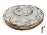trois assiettes garnies de coquillages, posées sur un fond blanc