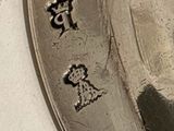 a silver plate with a picture of a woman on it