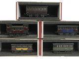 Six petits trains se trouvent dans une boîte posée sur une surface blanche.