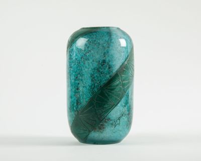 a glass vase with a leaf design on it