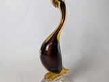 a glass sculpture of a bird on a clear base