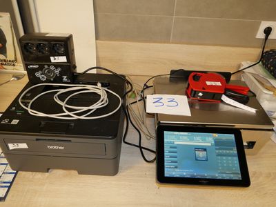 une tablette et une imprimante posées l'une à côté de l'autre sur un comptoir