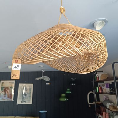 une lampe en osier suspendue au plafond dans une pièce
