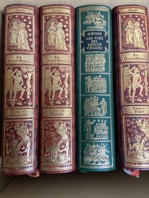 trois vieux livres sont alignés les uns à côté des autres sur une étagère