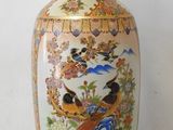 a vase with a bird design on it sitting on a table