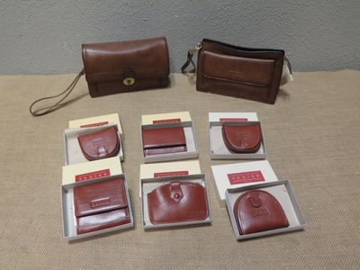 Plusieurs morceaux de cuir marron sont posés sur une table, à côté d'un sac à main.