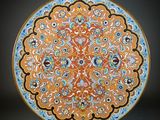 an orange and blue plate with a floral design on it