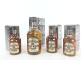 four bottles of liquor are lined up in a row on a white surface