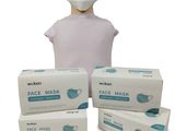 une personne portant un masque à côté de trois boîtes de masques