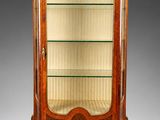 une vitrine ancienne avec des étagères en verre et des finitions dorées