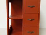 an orange cabinet with three drawers on top of it