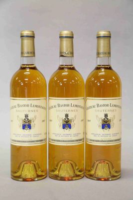 trois bouteilles de vin posées sur une table blanche