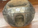 une boule métallique percée d'un trou, posée sur une table en bois