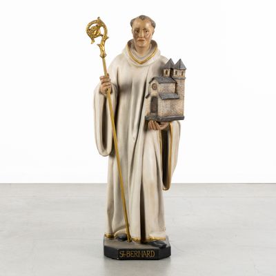 a statue of a man holding a book and a staff