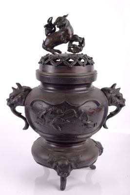 an image of a bronze vase with a bird on top