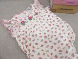 a white dress with pink flowers on it next to a box