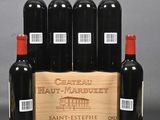 six bottles of red wine in a wooden crate on a table