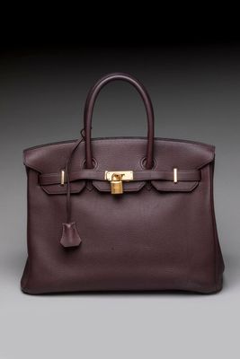 a brown leather handbag with a gold lock on the handle