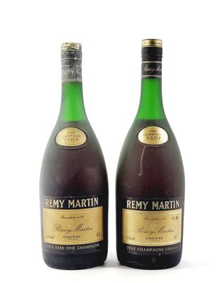 two bottles of wine sitting next to each other on a white surface