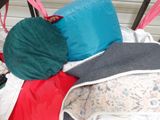 a pile of pillows and blankets on a bed