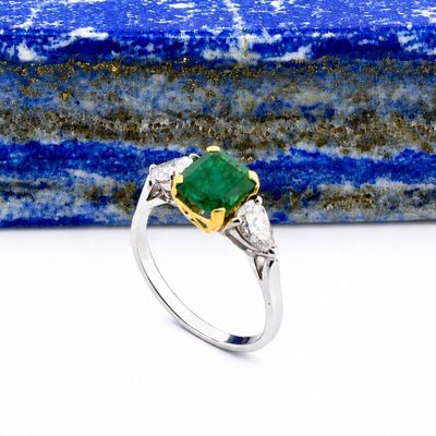 a close up of a ring with a green stone on it