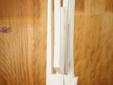 a white sculpture on a wooden stand with a hand reaching for it